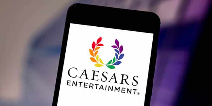 Logotipos da Caesars Entertainment e Fertitta Entertainment com cifrões e um aperto de mãos ao fundo, simbolizando o acordo de aquisição.