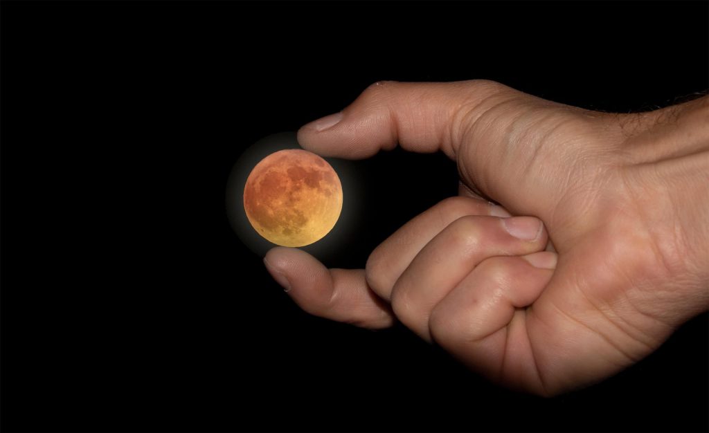 A Lua cheia visível no céu noturno, com um brilho suave e cercada por algumas estrelas, representando a Microlua Azul.