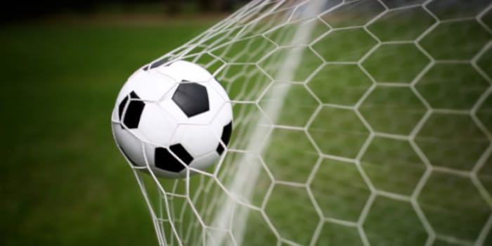 Jovem torcedor de futebol olhando para o celular, com um logo sutil de jogo responsável ao fundo, simbolizando a campanha da KSA.
