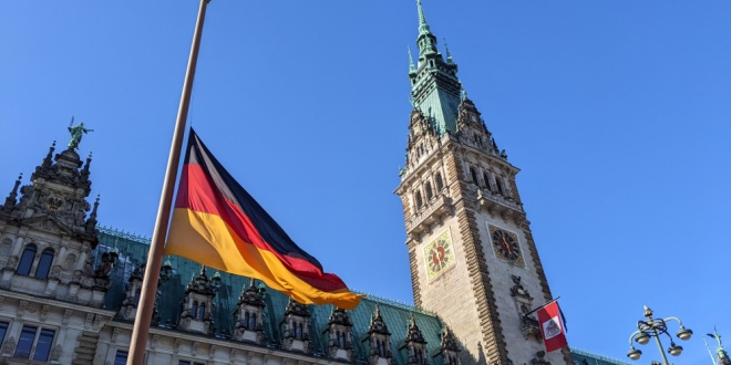 Fachada do Reichstag em Berlim, com documentos de regulação de jogos de azar em primeiro plano, simbolizando a legislação alemã sobre apostas.