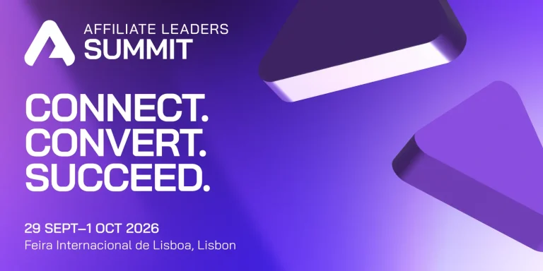 Pessoas participando de uma conferência de negócios em um grande salão de exposições em Lisboa, com painéis de LED e estandes de empresas.