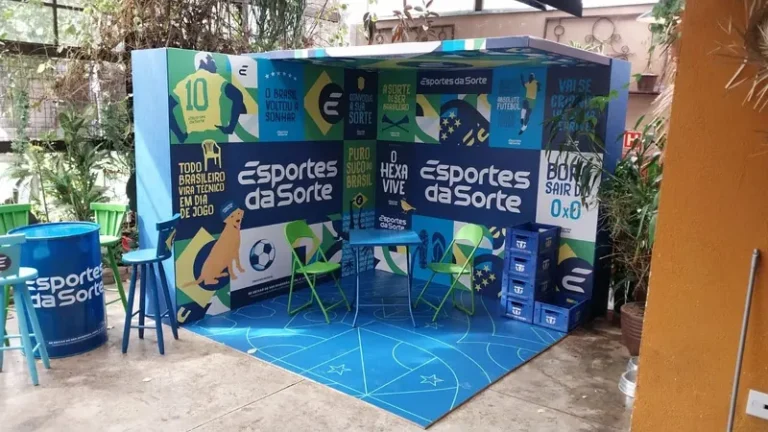 Torcedores em um bar animado assistindo a um jogo da Copa do Mundo, com bebidas e petiscos nas mesas.
