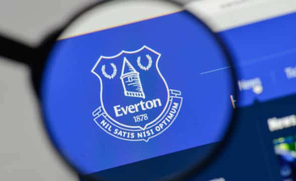 Jogadores do Everton em campo com o logo da Stake na manga da camisa, refletindo as novas regras de patrocínio.