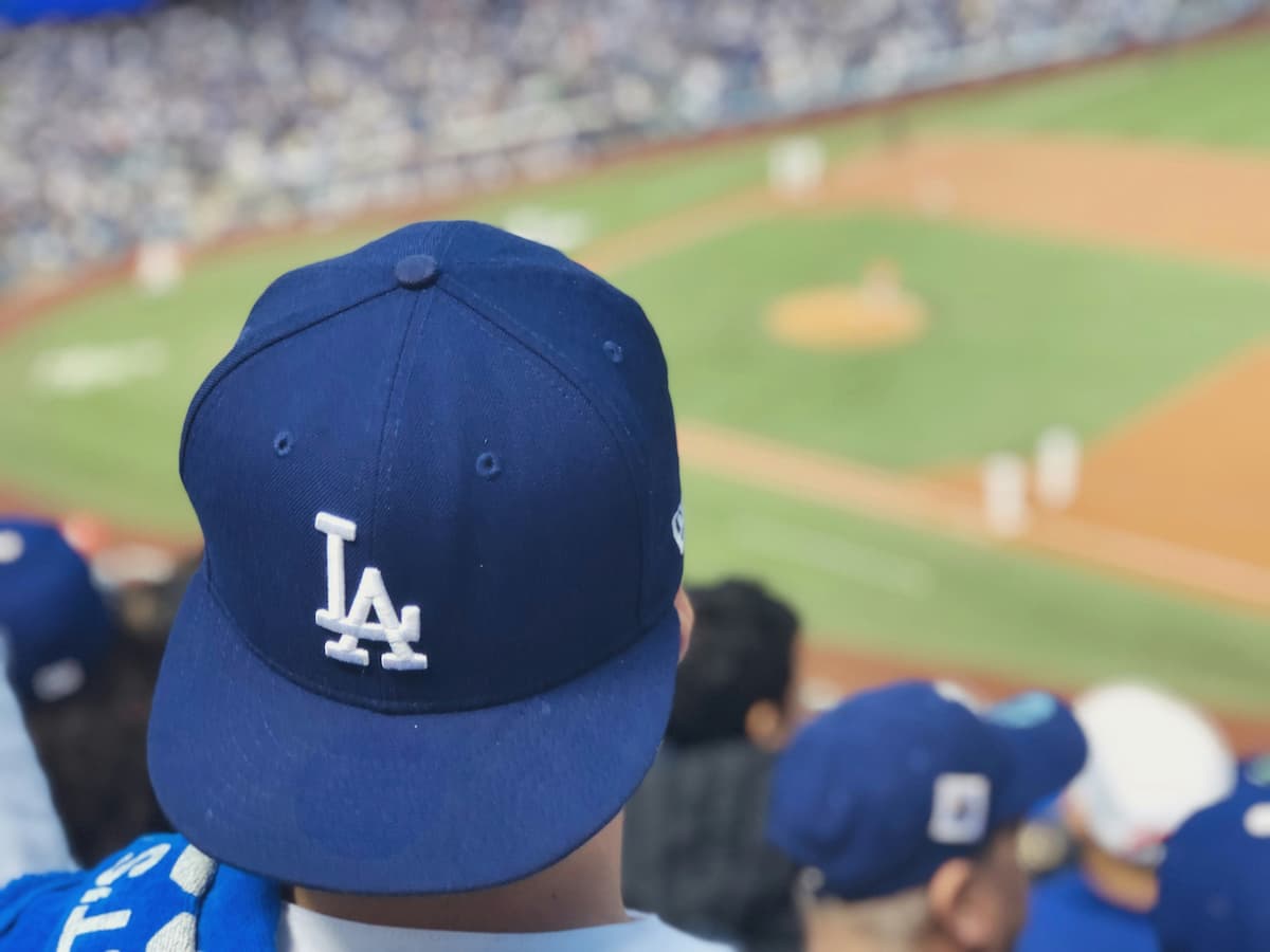 Estádio de beisebol iluminado durante partida da MLB com placar eletrônico ao fundo.